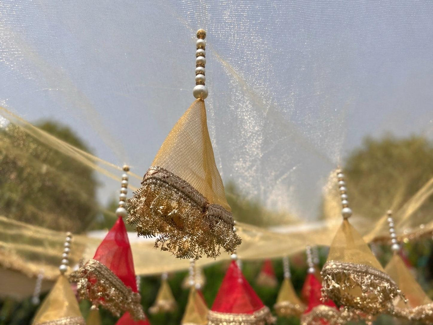 Decorative headpieces with gold and red colors against a blurred natural background