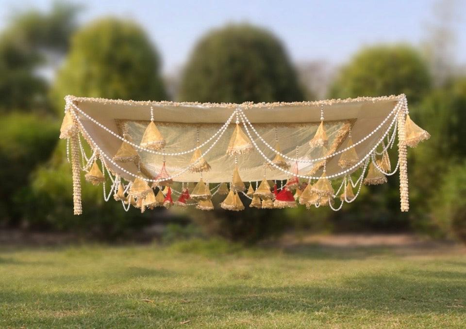 Decorative canopy with lights and flowers on a grassy field