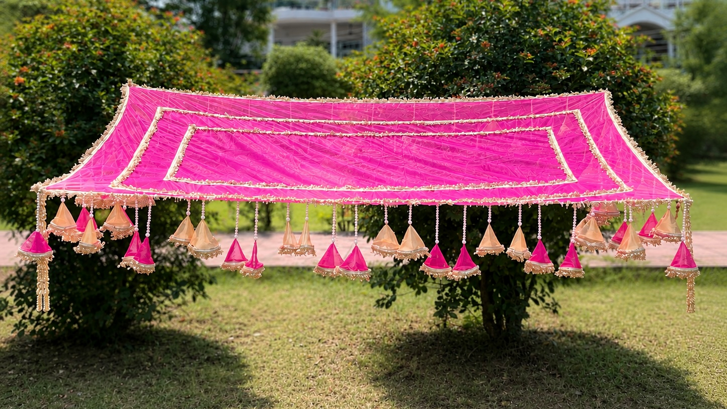 Decorative pink canopy tent with hanging decorations on a grassy area