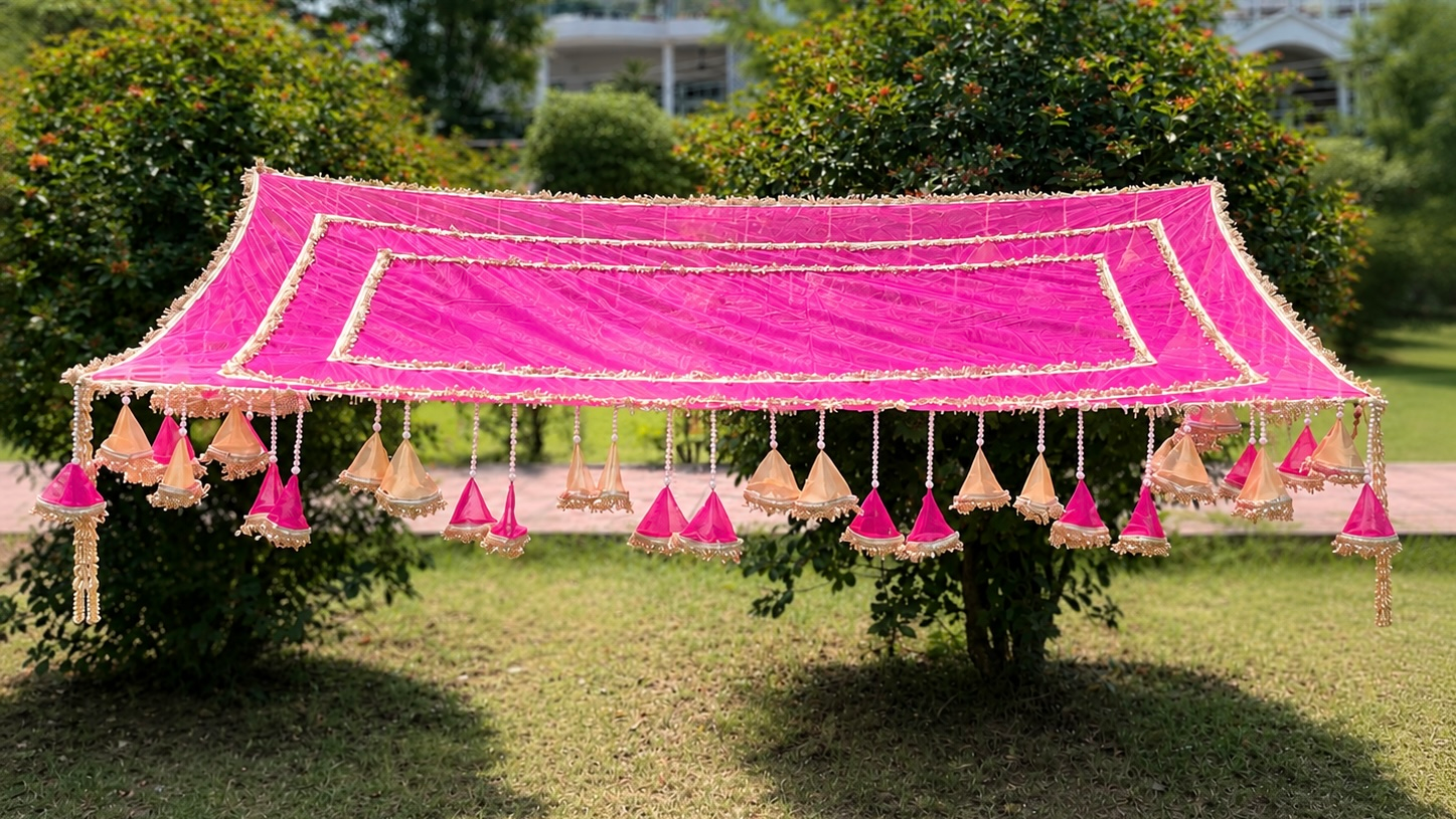 Decorative pink canopy tent with hanging decorations on a grassy area