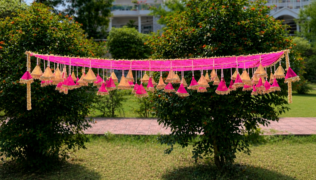 Decorative hanging lights with pink ribbons on a tree in a garden setting