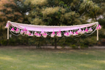 Decorative pink fabric with floral elements hanging outdoors
