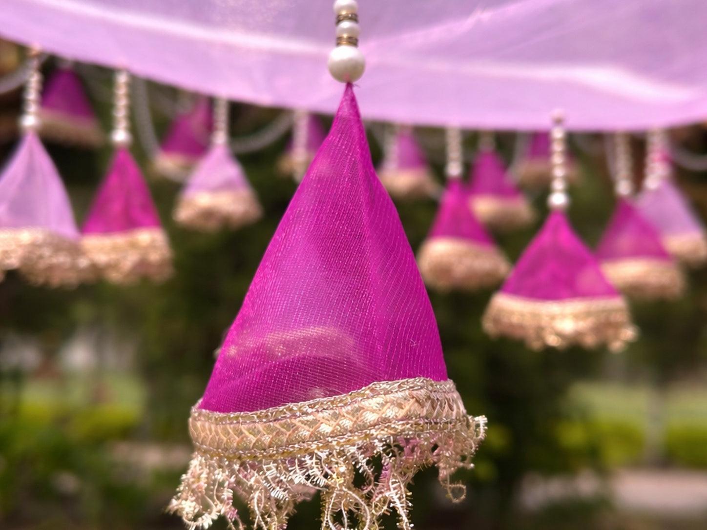 Decorative purple and gold fabric hanging with blurred greenery in the background