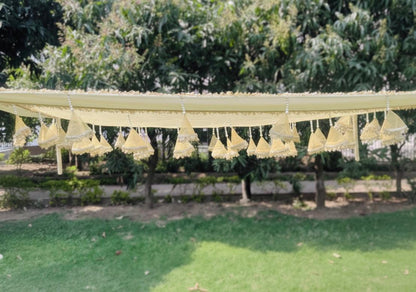 Decorative hanging elements on a string against a green outdoor background