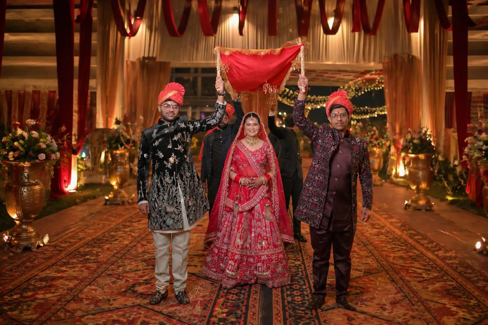 Traditional Indian wedding ceremony with bride and groom in ornate attire, surrounded by decorations.