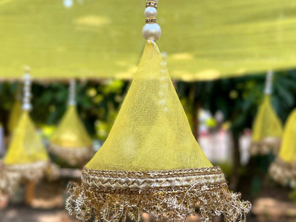 Decorative yellow umbrella with gold trim against a blurred green background