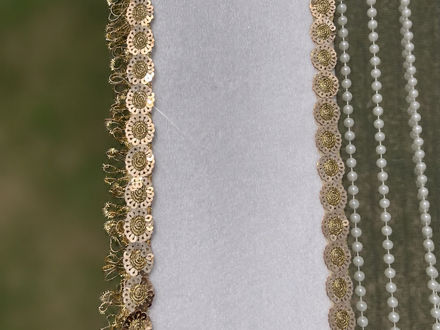 Decorative gold and pearl trim on a fabric background