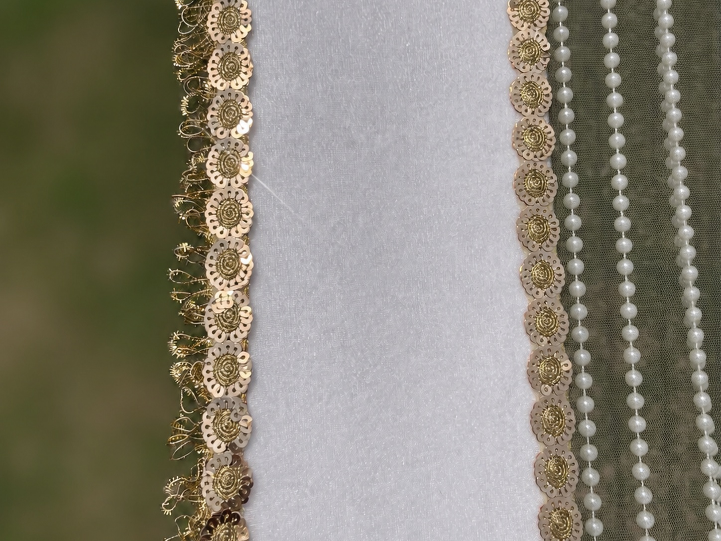 Decorative gold and pearl trim on a fabric background