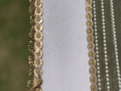 Decorative gold and pearl trim on a fabric background