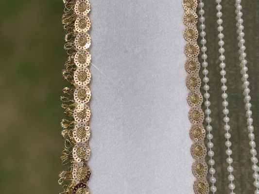 Decorative gold and pearl trim on a fabric background