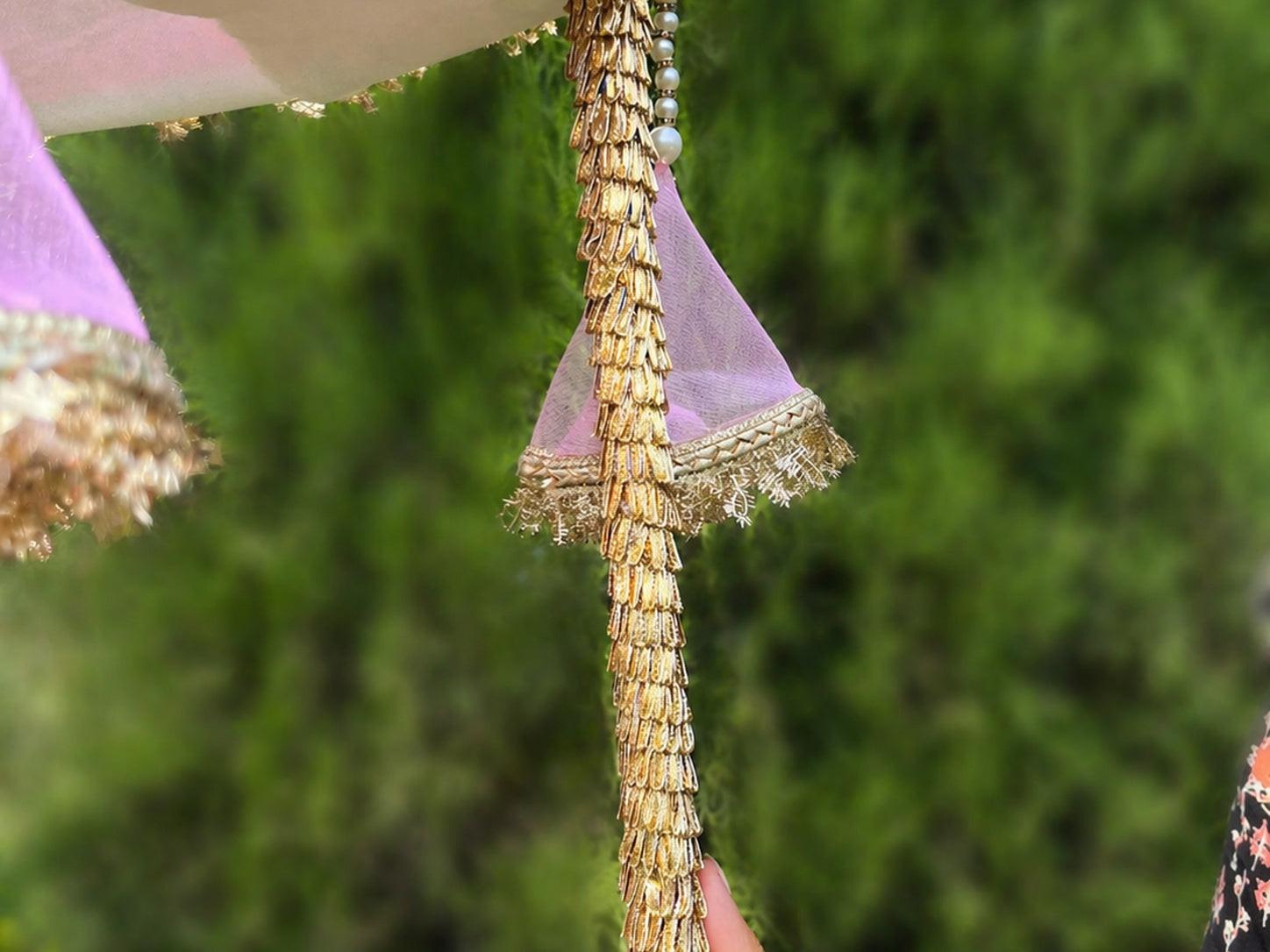 Close-up of a decorative item with gold and purple elements against a blurred green background