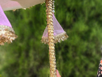 Close-up of a decorative item with gold and purple elements against a blurred green background