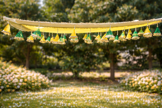 Decorative yellow canopy with hanging green lanterns over a garden.